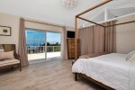 Tastefully decorated master bedroom with king bed and exit to upper porch area with views